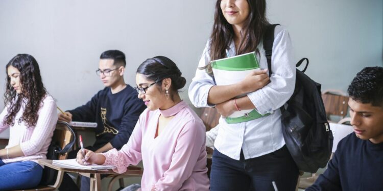 woman carrying white and green textbook