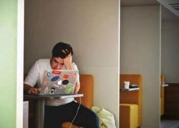 man wearing white top using MacBook