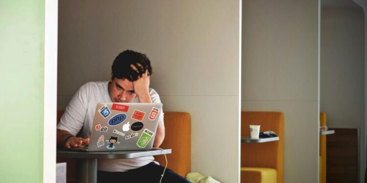 man wearing white top using MacBook